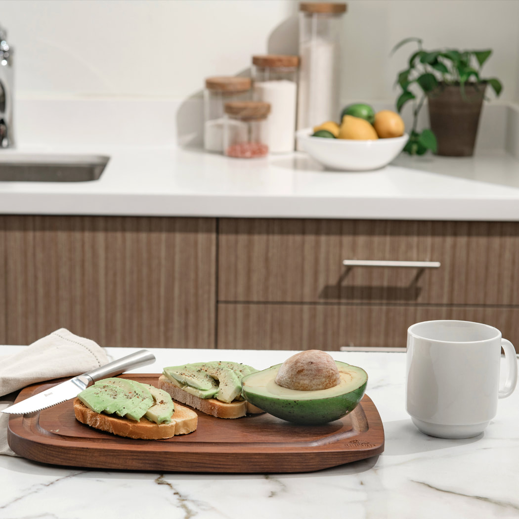 Kitchen image with wood board, mug, avocado and avocado toast